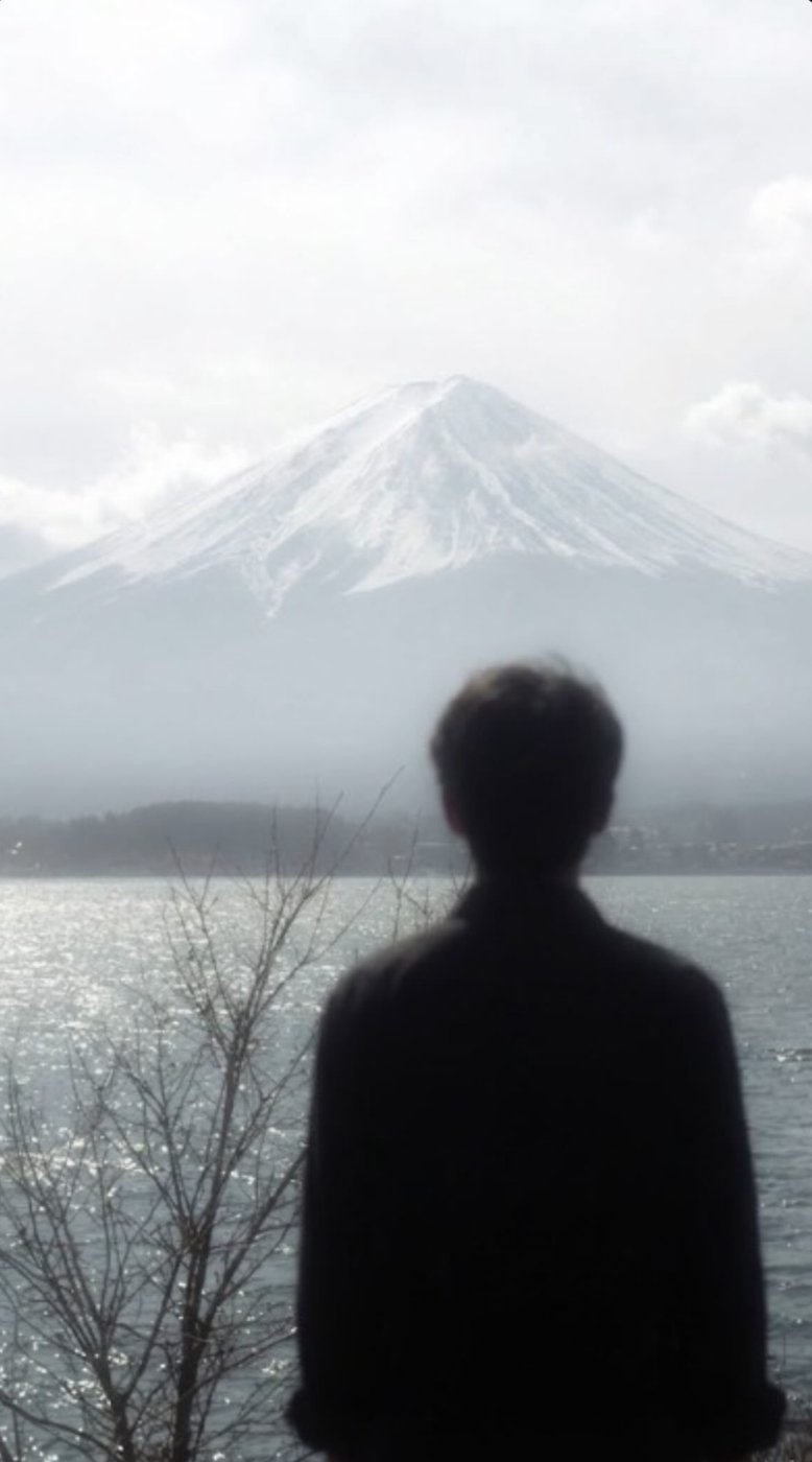 Jacob looking out at a snow-capped mountain over a lake