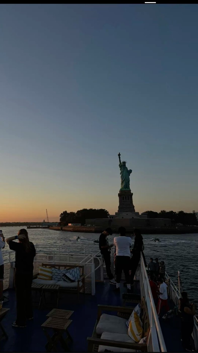 Statue of Liberty at sunset from a ferry deck